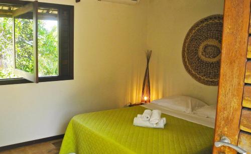 a bedroom with a bed with two towels on it at Paraiso Tropical - Casa 7 in Pipa