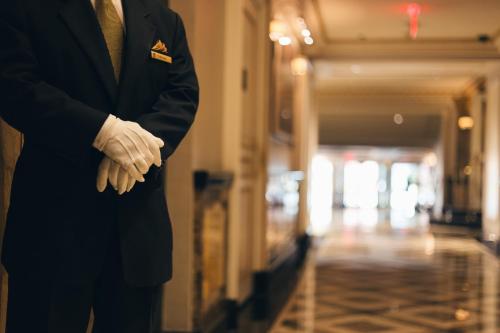 a man in a suit and tie with his hands in a hallway at The Pierre, A Taj Hotel, New York in New York