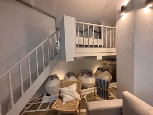 a living room with a staircase with vases on the floor at Maison Strelitzia "Heritage" - Adults Only in Skiathos Town