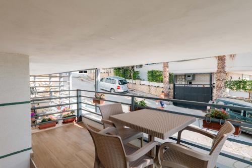 a balcony with a table and chairs and a car on a street at Roan Apartments in Sarandë