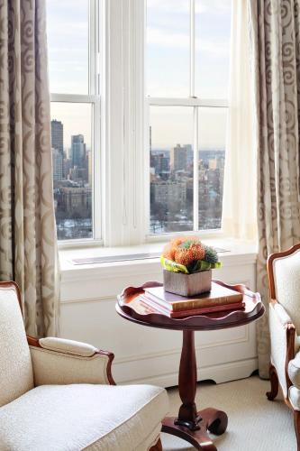 a living room with a table and a window at The Pierre, A Taj Hotel, New York in New York