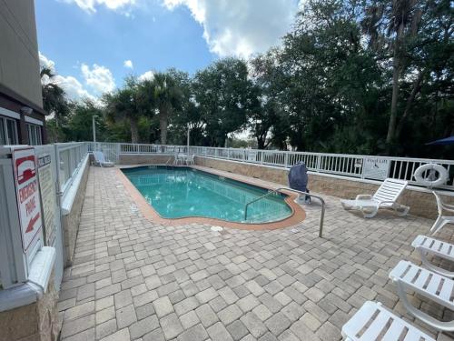a small swimming pool with a chair and a patio at Fairfield by Marriott Inn & Suites Melbourne West/Palm Bay in Melbourne