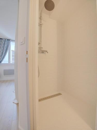 une salle de bain avec une douche avec une porte vitrée dans l'établissement Charmant deux pièces en cœur de ville, à Sète