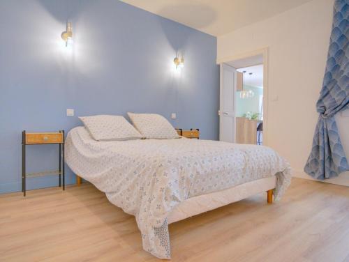 une chambre avec un lit et un mur bleu dans l'établissement Charmant deux pièces en cœur de ville, à Sète