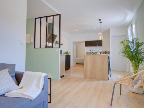 un salon avec un canapé bleu et une cuisine dans l'établissement Charmant deux pièces en cœur de ville, à Sète