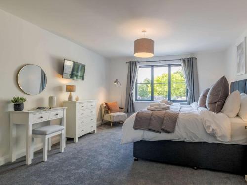 a bedroom with a bed and a desk and a mirror at 2 Bed in Usk 83993 in Trostrey