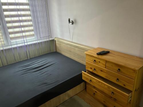 a room with a bed and a dresser and a window at Mieszkanko na Traugutta in Płock