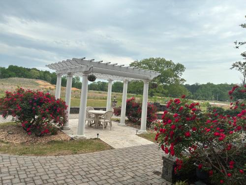 a white gazebo with a table and some flowers at Comfort Inn & Suites Near Lake Guntersville in Scottsboro