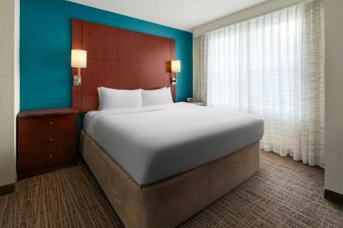 a bedroom with a large bed and a blue wall at Residence Inn Florence in Florence