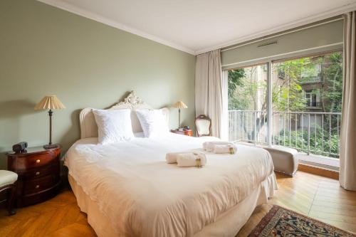 une chambre avec un grand lit avec deux serviettes dessus dans l'établissement Appartement de la Tour - Welkeys, à Paris