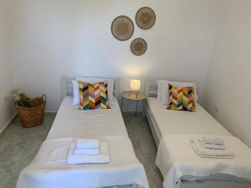 two beds in a room with a table and a lamp at Eraora Lofts & Appartments Kefalonia in Lakithra