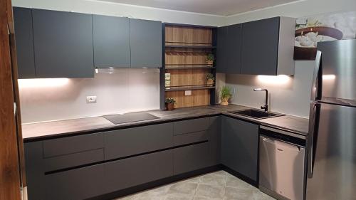 a kitchen with gray cabinets and a stainless steel refrigerator at Luxury Suite Quartu in Quartu SantʼElena