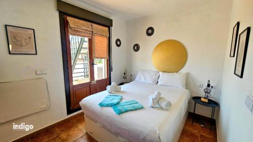 een slaapkamer met een wit bed met handdoeken erop bij ANN001 Bright Two Bedroom Townhouse in Ayamonte