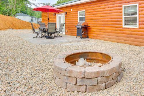 a stone fire pit in front of a house at 15 Mi to Pigeon River Rafting Newly Built Cabin! in Newport