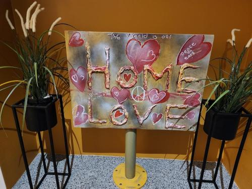 a sign that says the world is out of love with two plants at Base apartments ap 204 - Capital region of Reykjavík in Hafnarfjördur
