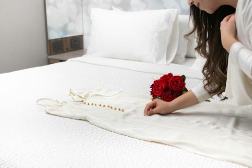 a woman laying on a bed with a bouquet of roses at Courtyard by Marriott Mexico City Vallejo in Mexico City