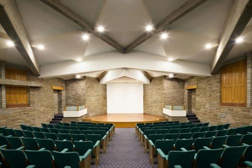 an empty auditorium with green chairs and a stage at Marriott Puebla Hotel Meson del Angel in Puebla