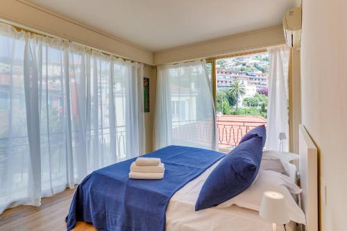 une chambre avec un lit avec des draps bleus et une fenêtre dans l'établissement Dina palace AP4462 By Riviera Holiday Homes, à Villefranche-sur-Mer