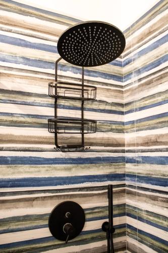 a bathroom with a striped wall with a light fixture at Casa Baí in Torre Nubia