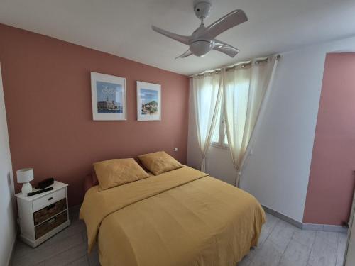 une chambre avec un lit et un ventilateur de plafond dans l'établissement Villa Cevalia, à Balaruc-les-Bains