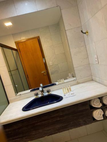 a bathroom with a sink and a mirror at Colonial Plaza Hotel Pindamonhangaba in Pindamonhangaba