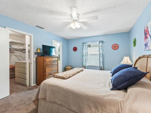 a bedroom with blue walls and a bed with a ceiling fan at 2 Bedroom 2 Bath Patio Villa in The Villages