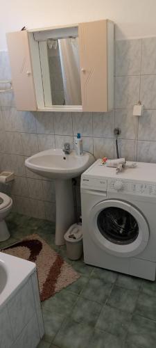 a bathroom with a washing machine and a sink at Apartments Cinderella with City View in Mostar