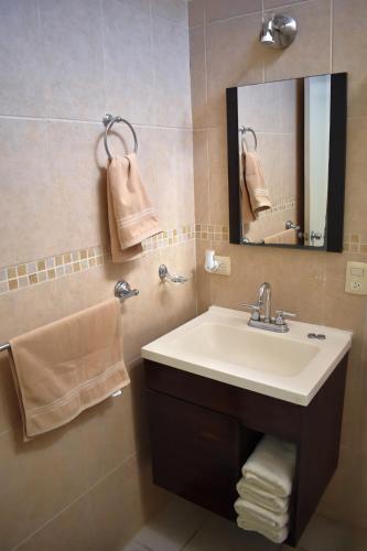 a bathroom with a sink and a mirror and towels at House equipped with two bedrooms in La Paz