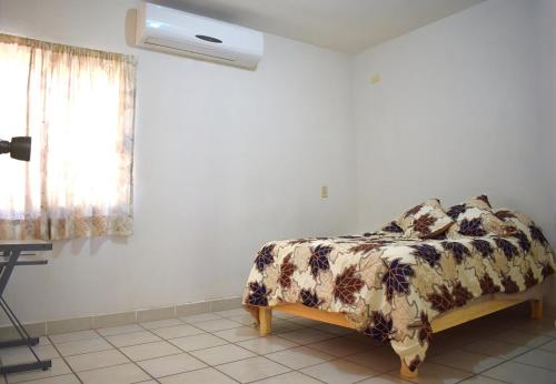 a bedroom with a bed with a blanket and a window at House equipped with two bedrooms in La Paz