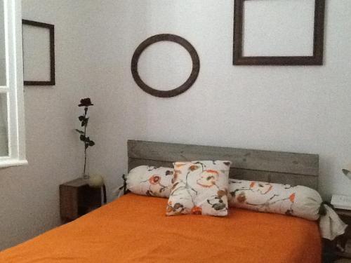 une chambre avec un lit orange avec des oreillers et un miroir dans l'établissement Maison de vacances, à La Celle-sous-Gouzon