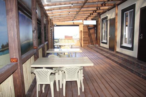 ノヴォロシースクにあるAleksino Guest house (Laguna)の木製デッキ(テーブル2台、椅子2脚付)