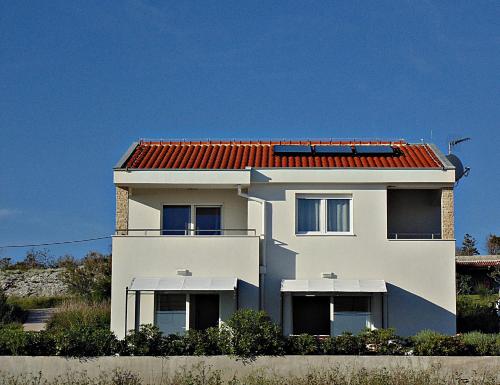 a white house with a red roof at House Natali 70m from the beach - free EV top up in Rtina