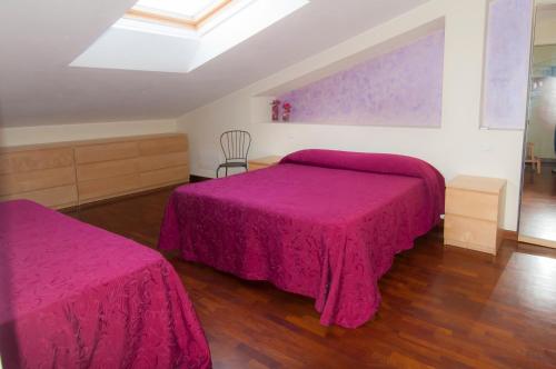 a bedroom with two beds with pink sheets at B&B Alle Tre Rose in Montignoso