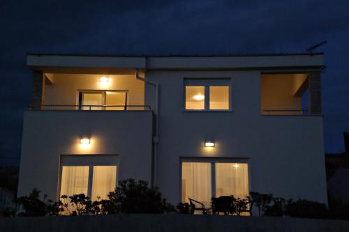 a white house with lights in the windows at night at House Natali 70m from the beach - free EV top up in Rtina