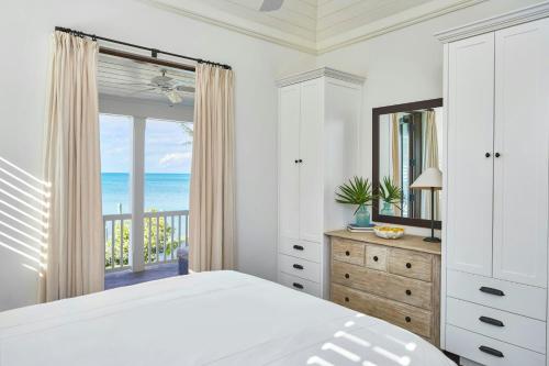 a bedroom with a bed and a view of the ocean at French Leave Resort, Autograph Collection in Governorʼs Harbour
