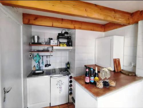 eine Küche mit weißen Wänden und Holzdecken in der Unterkunft Appartement contemporain à La Seyne-sur-Mer, 30 m², terrasse in La Seyne-sur-Mer