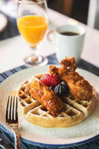a plate with chicken wings and waffles and a cup of coffee at Le Meridien Atlanta Perimeter in Atlanta