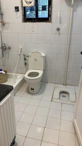a white bathroom with a toilet and a sink at فيلا مطله in Muqammar