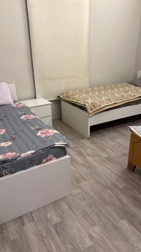 two beds sitting in a room with wooden floors at فيلا مطله in Muqammar