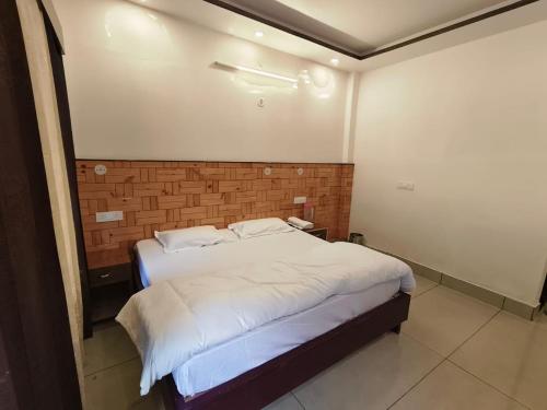 a bedroom with a bed with a brick wall at Hotel Kailash in Harsil