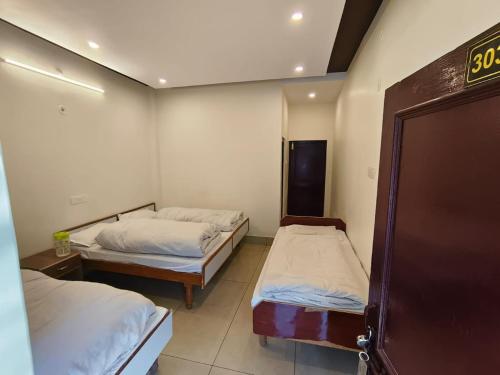 a room with two beds in a room with at Hotel Kailash in Harsil