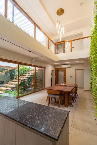 an open kitchen and dining room with a wooden table at Hossana Modern Wedge Villa in Kovalam