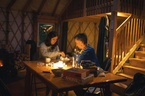 two people sitting at a table in a room at Cozy Yurt in the Woods in Sainte-Agathe-des-Monts