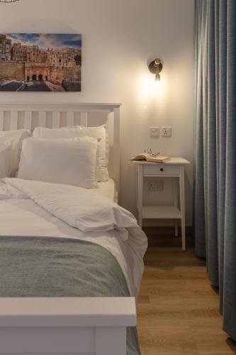 a bedroom with a bed and a table with a lamp at Roel Boutique B&B in Cospicua