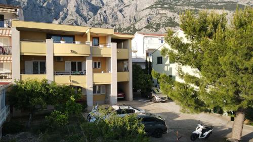 an apartment building with cars parked in a parking lot at Dijana in Makarska