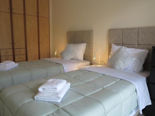zwei Betten mit Handtüchern in einem Schlafzimmer in der Unterkunft ELIRA - City Apartment, Lefkada in Lefkada Town