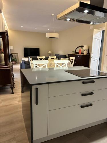 a kitchen with a counter top and a living room at La Casa Alandí con garaje privado in Sagunto