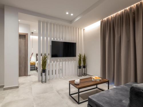 a living room with a couch and a tv at Ergina Apartments Gournes Studio & Family Apartment in Gournes