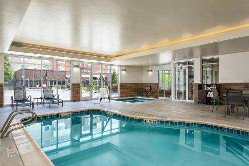 a swimming pool in a hotel lobby with chairs and tables at Fairfield Inn & Suites by Marriott Twin Falls in Twin Falls