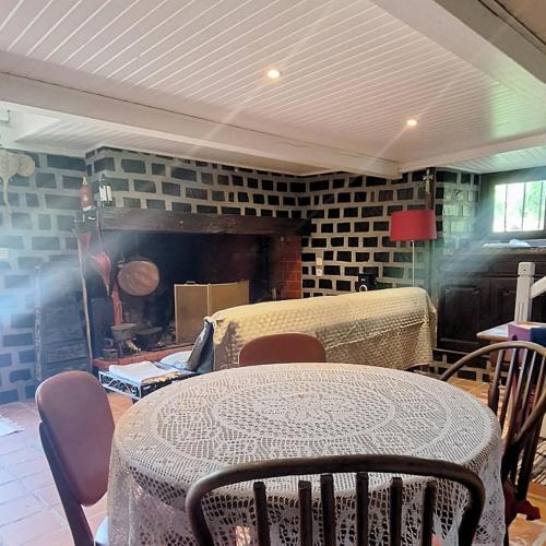 a room with a table and chairs and a fireplace at Mountain guest house in Ségus